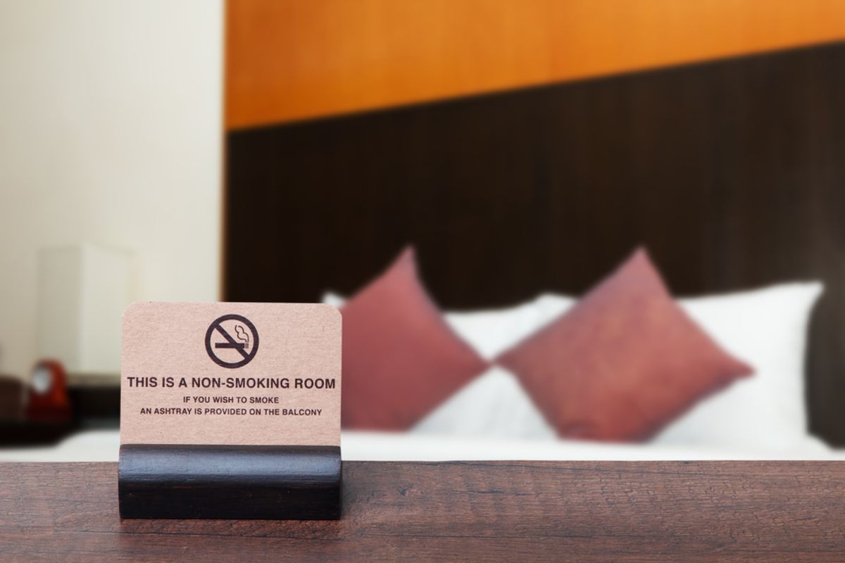 Trik santai melakukan negosiasi saat tertangkap basah merokok di hotel agar biayanya lebih ringan.